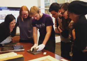 Students in the Italian Civilization II class examine a 1593 edition of a book as part of their investigation into Early Modern print culture in Italy