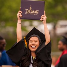 Graduate holding up diploma