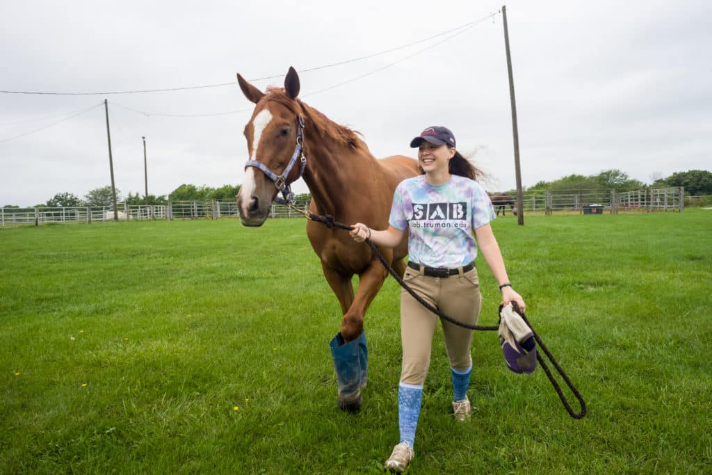A student walking with a hose